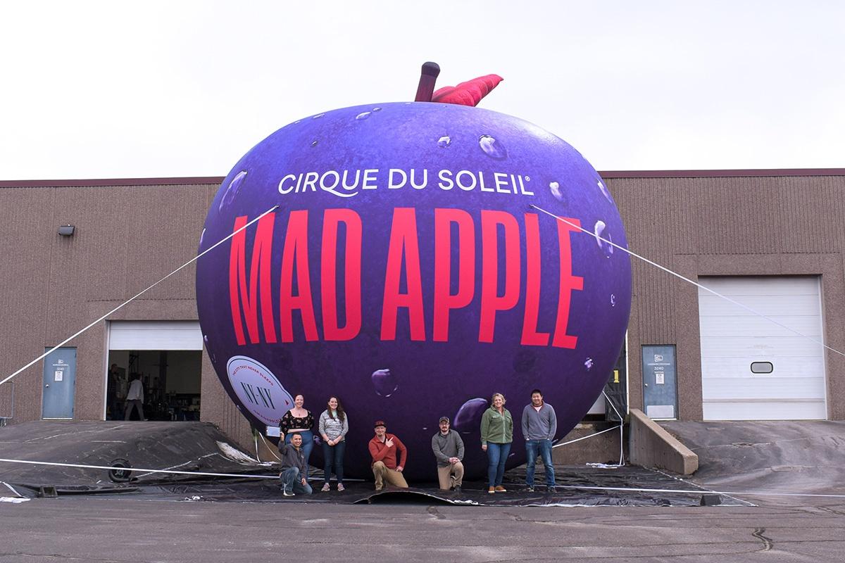 Team Landmark group shot in front of Mad Apple custom inflatable for Cirque du Soleil
